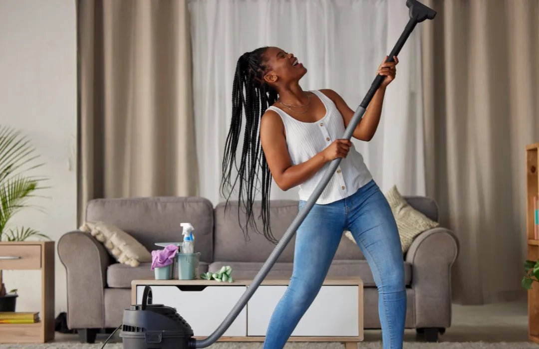 Photo of a happy person vacuuming the house