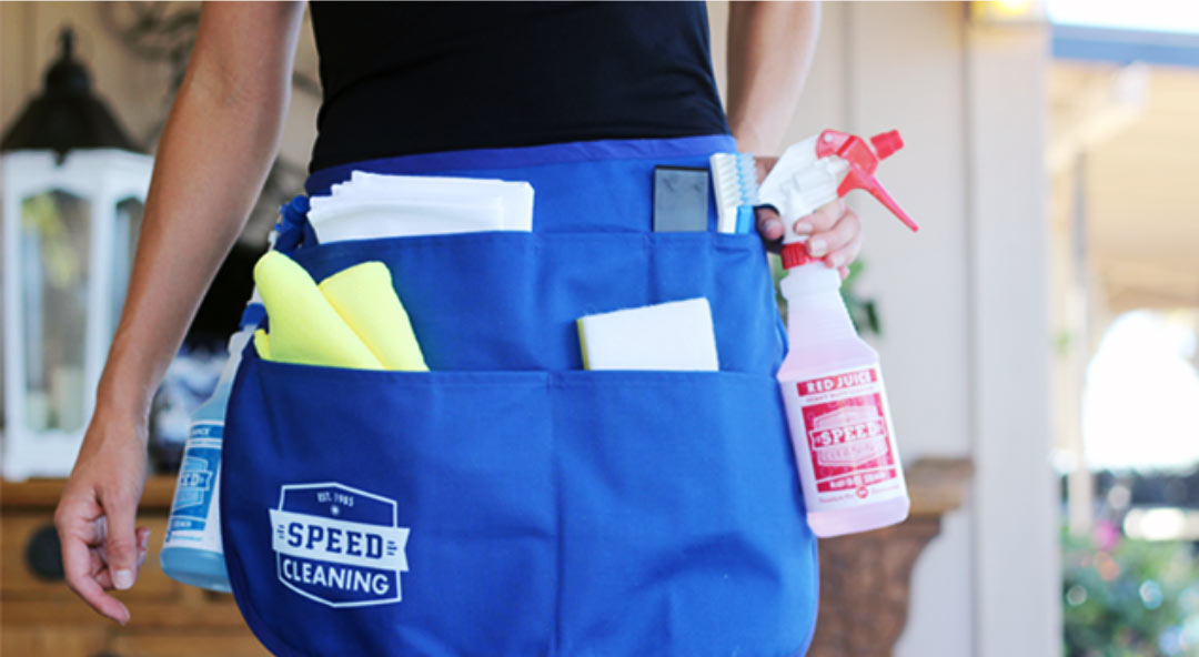 Closeup of the original Speed Cleaning blue cleaning apron with the Speed Cleaning logo in white on the lower left-hand pocket.